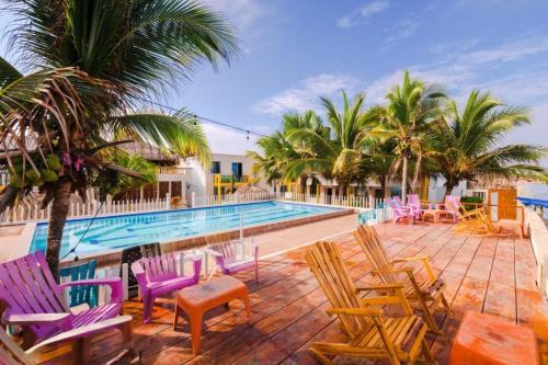 a swimming pool with colorful chairs and a swimming pool at Cabaña en condominio frente al mar #10 in Tolú