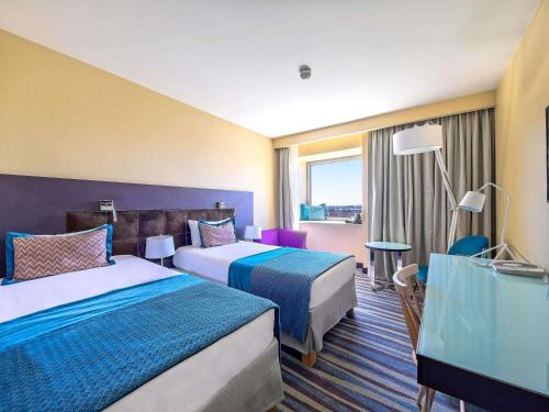 Una habitación de hotel con dos camas y una ventana. en Mercure Gdańsk Stare Miasto, en Gdansk