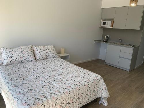 Un pequeño dormitorio con una cama y una cocina. en M Tower, en Neuquén