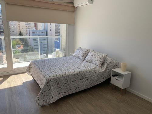 Un dormitorio con una cama y una ventana grande. en M Tower, en Neuquén