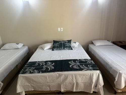 Dos camas una al lado de la otra en una habitación. en Hotel Fazenda Haras RD, en Olímpia