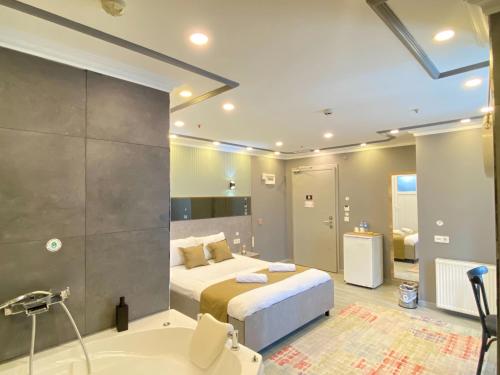 a bedroom with a bed and a bath tub and a bathroom at Sahrakent Otel Pendik in Istanbul