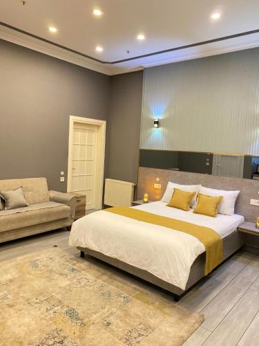 a bedroom with a large bed and a couch at Sahrakent Otel Pendik in Istanbul