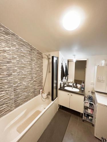 a bathroom with a tub and a sink at Superbe appart design - Rooftop privé proche Paris in Neuilly-sur-Marne
