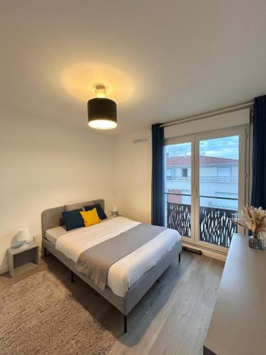 a bedroom with a bed and a large window at Superbe appart design - Rooftop privé proche Paris in Neuilly-sur-Marne