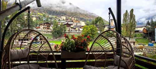 un balcon avec deux chaises avec un pot de fleurs dessus dans l'établissement house by the river, à Mestia