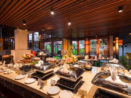 Un restaurante con tres lavabos con pájaros encima. en Mercure Kuta Bali, en Kuta