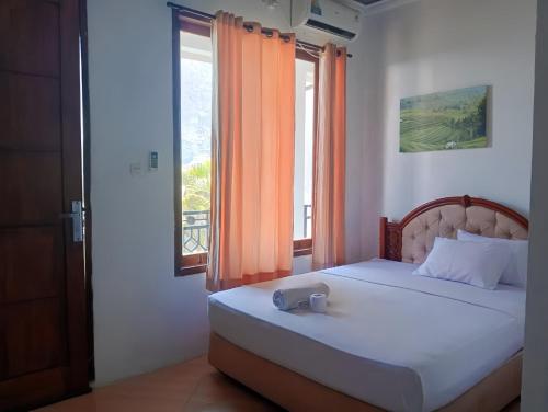 a bedroom with a bed with an open window at Ayu Homestay in Kuta Lombok
