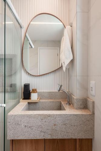 a bathroom with a sink and a mirror at Camurim Residence in Maragogi