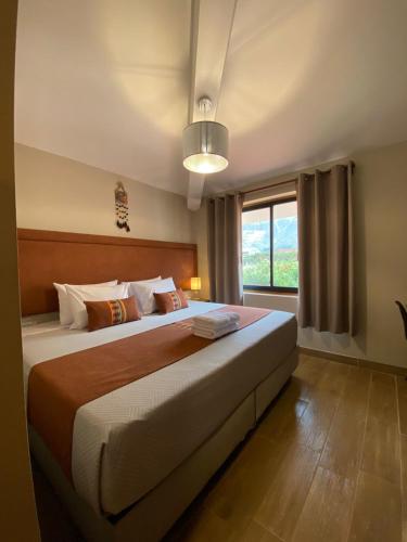 a bedroom with a large bed and a window at Oro Andino Lodge in Caraz
