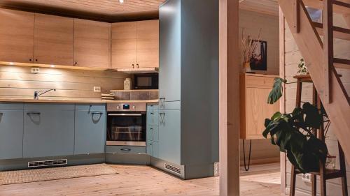 a large kitchen with blue cabinets and a staircase at Ferienhaus in Vrådal Norwegen in Vradal