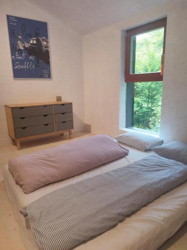 a bedroom with a bed and a dresser and a window at Romantický domek Slapy in Brunšov