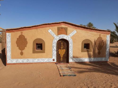 Una pequeña iglesia con una puerta en el desierto en Camp sahara, en Oulad Akkou