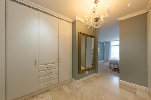 a bedroom with a mirror and a chandelier at Unit 1101 Oyster Rock in Durban