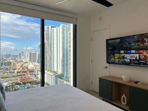Un dormitorio con una gran ventana con vista a una ciudad. en Luxury experience - views of MIAMI city center, en Miami