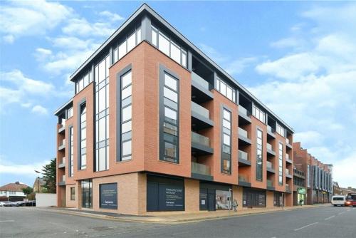 a large brick building on the side of a street at Brand-New Luxury Apartment Terrace - Opposite Piccadilly Line - 1-8 Guests in Uxbridge