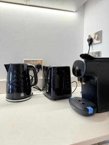 two microwaves sitting on a counter in a room at West London Residences - Private Terrace - Opposite Piccadilly Line 20min SOHO Oxford Street in Uxbridge