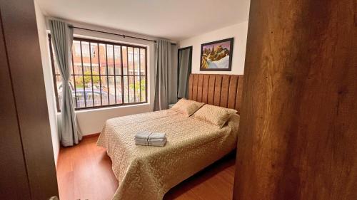 a small bedroom with a bed and a window at Dúplex familiar cerca al Cable y Milán con patio in Manizales