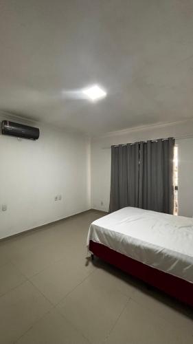 a bedroom with a bed and a window at Quarto Porto in Porto Seguro