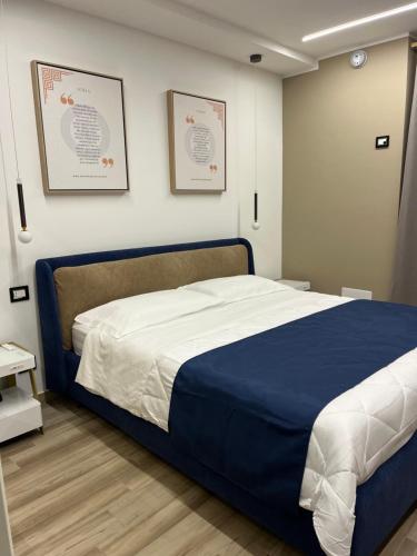 a bedroom with a blue and white bed with two pictures on the wall at Omero in Reggio di Calabria