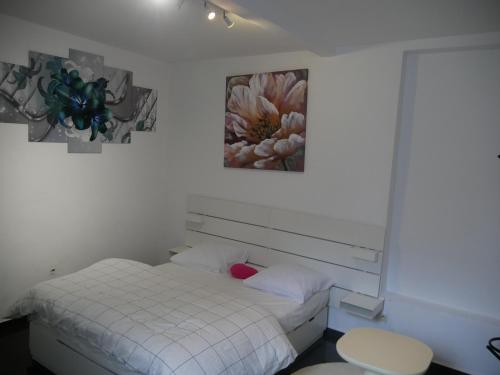 a bedroom with a white bed and a painting on the wall at VancyLove Home in Mons