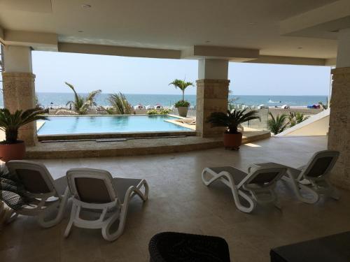un vestíbulo con sillas y una piscina en Cartagena Beach Front, en Cartagena de Indias