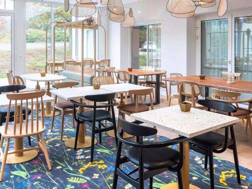 a restaurant with tables and chairs on a rug at ibis Styles Pontivy centre Bretagne in Pontivy