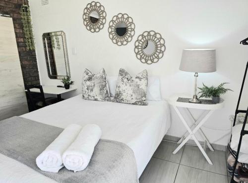 a bedroom with a bed with pillows and a mirror at Zhantique Guest House 1- Unit 2 in Boksburg