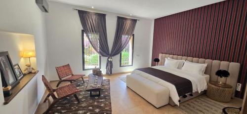 Un dormitorio con una cama grande y una mesa y sillas. en villa Bidouane, en Marrakech