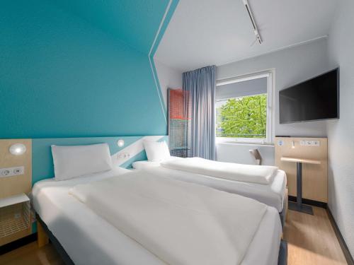 two white beds in a room with a window at ibis budget Hamburg St Pauli Messe - neu renoviert in Hamburg