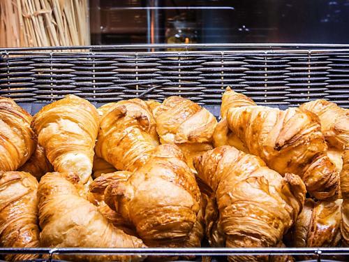 a bunch of croissants sitting on a rack in a bakery at Hotel ibis Lisboa Alfragide in Lisbon