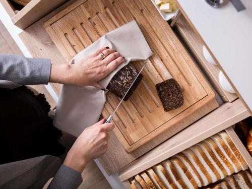 a woman holding a knife in a box of food at Novotel Vilnius Centre in Vilnius