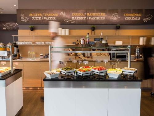 a food counter with several bowls of food on it at Novotel Vilnius Centre in Vilnius