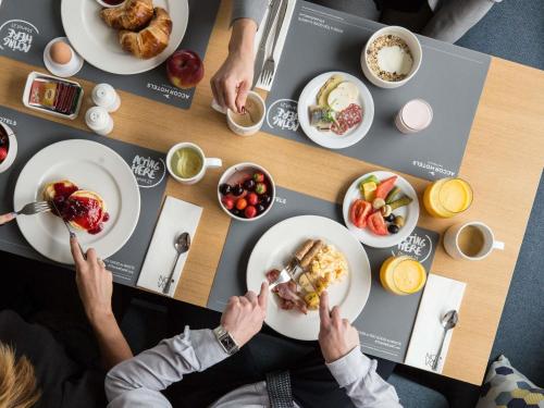 a group of people sitting at a table eating food at Novotel Vilnius Centre in Vilnius