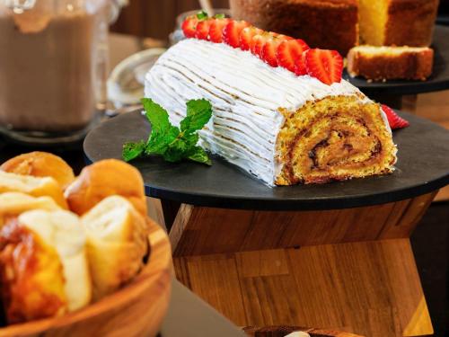 un gros gâteau sur une table avec un panier de pain dans l'établissement ibis Belo Horizonte Liberdade, à Belo Horizonte