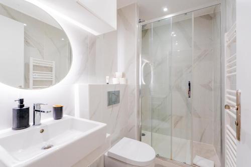 a white bathroom with a sink and a shower at Luxurious Apartment Stylish Design - René Boulanger in Paris