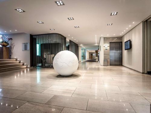 a large white ball sits in the middle of a lobby at Pullman Eindhoven Cocagne in Eindhoven