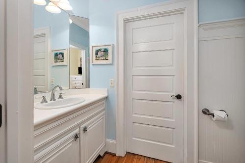 a white bathroom with a sink and a mirror at 4205 Ninth Street in Saint Simons Island