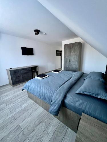 a bedroom with a large blue bed and a fireplace at La Izvor Moinești, Cazare in Moineşti