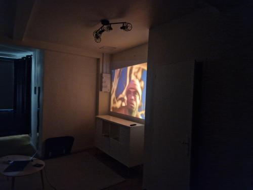 a dark room with a large projection screen on the wall at Appartement Victoire in Bordeaux
