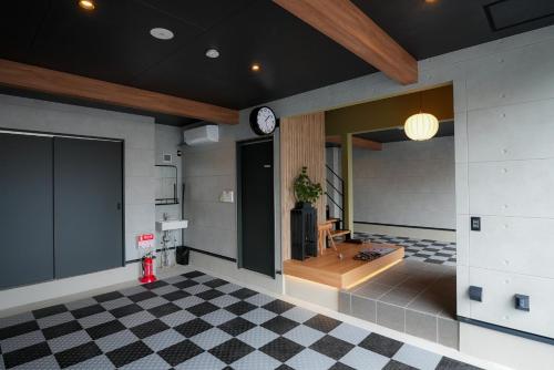 a room with a clock on the wall and a checkered floor at Tabiudo Stay Miyajima 01-02 - Vacation STAY 20514 in Fukae