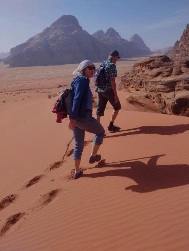 two people walking on the sand in the desert at Wadi Rum Abu Khaled in Wadi Rum