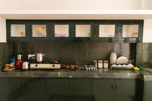 eine Küche mit grünen Schränken und einer Arbeitsplatte in der Unterkunft The Hidden Gem, Your Perfect Hideaway in Hyderabad