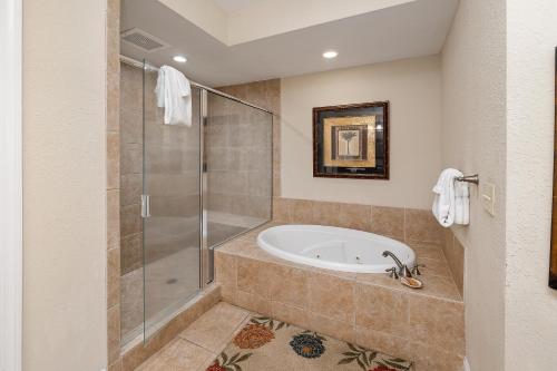a bathroom with a tub and a shower at 760 Ocean Blvd #204 in Saint Simons