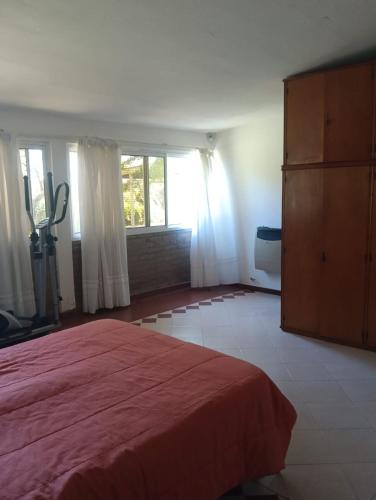 a bedroom with a red bed and a large window at Los Algarrobos in Bialet Massé
