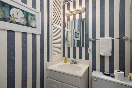 un baño con lavabo y espejo en Island Townhouse #E1, en East End