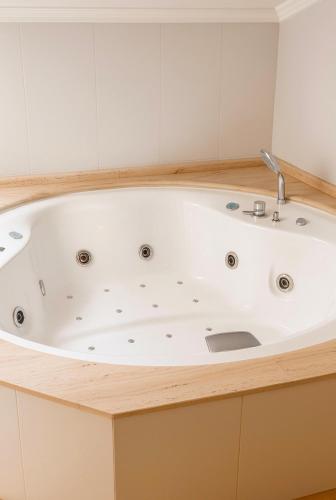 a bath tub in a bathroom with a sink at Hotel Villa de Cacabelos in Cacabelos
