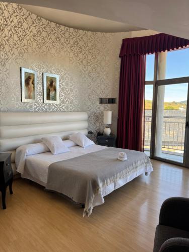 a bedroom with a large bed and a large window at Hotel Villa de Cacabelos in Cacabelos