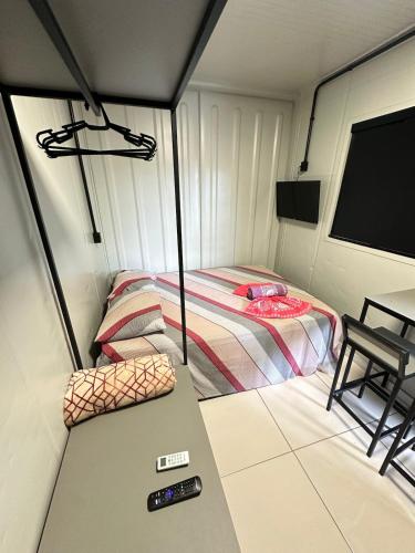 a small room with a bed and a television at Loft privativo próximo ao Amaral in Jaú