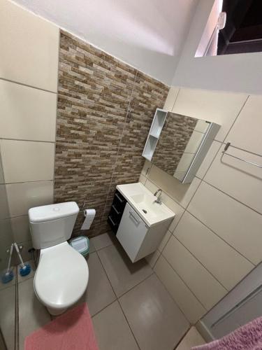 a bathroom with a white toilet and a sink at Loft próx. Amaral C. e Shopping in Jaú